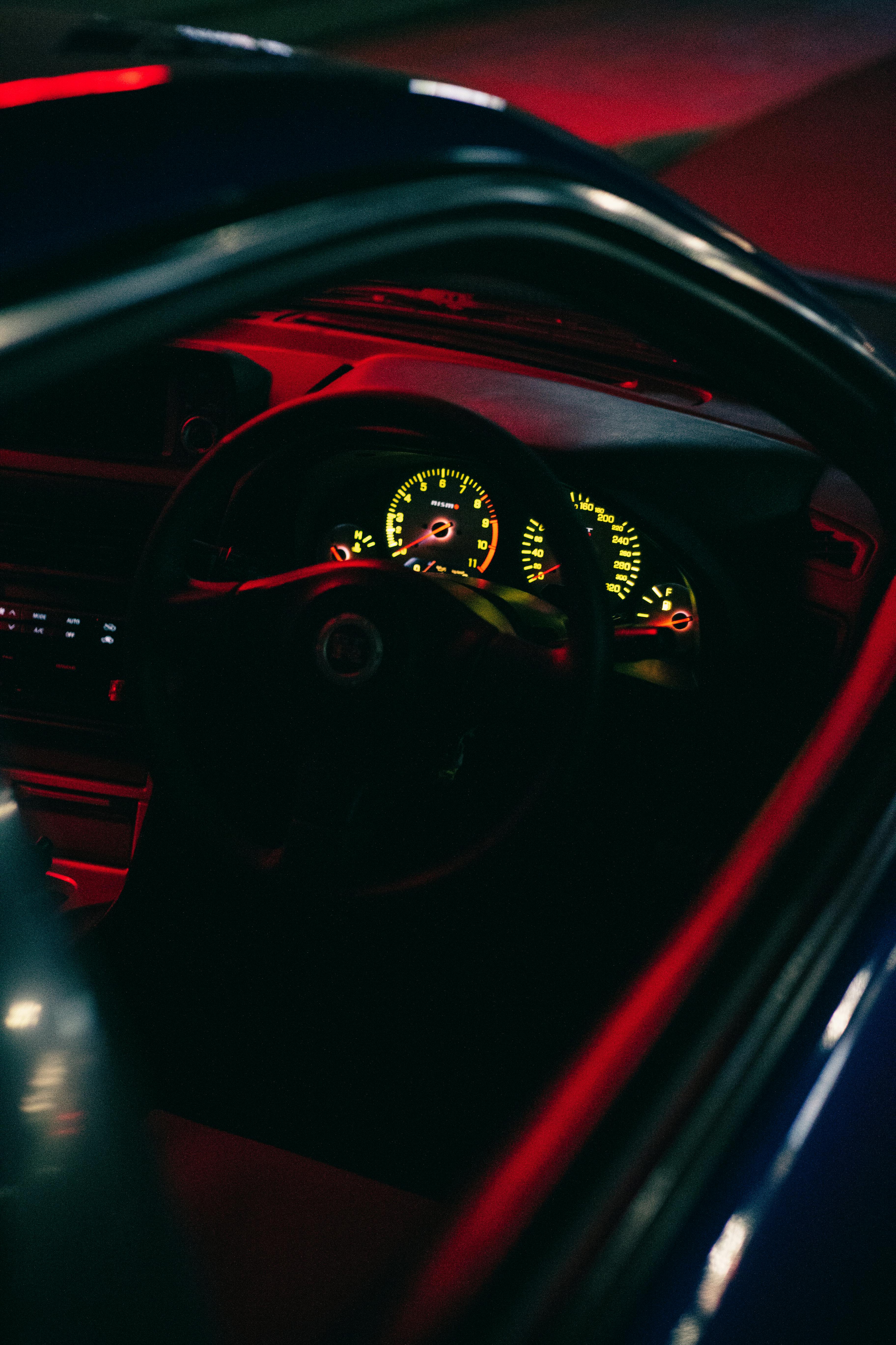 Interiorul mașinii noaptea, vedere spre volan și instrumente