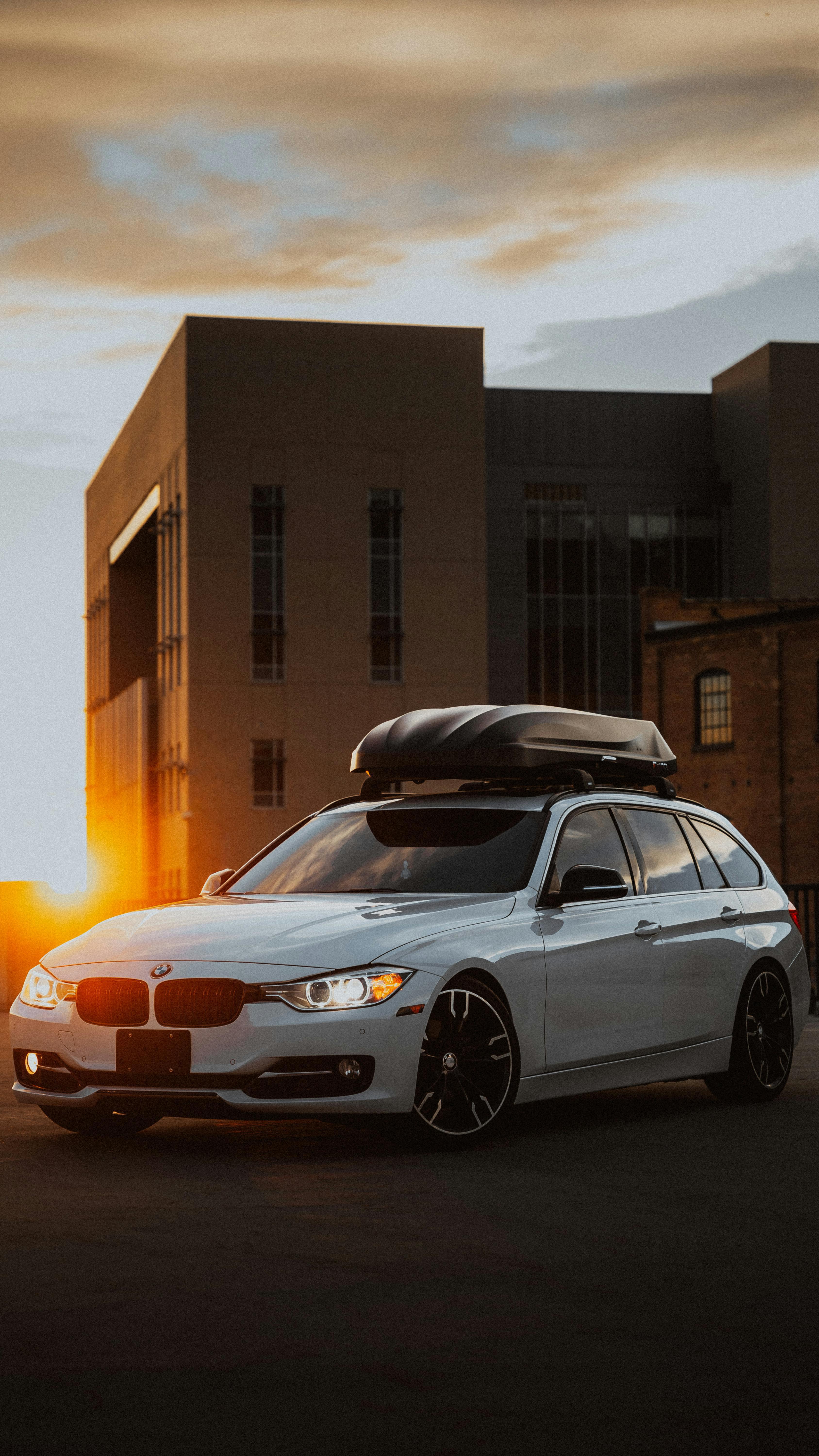 Автомобиль с багажником-боксом на крыше на вечерней дороге