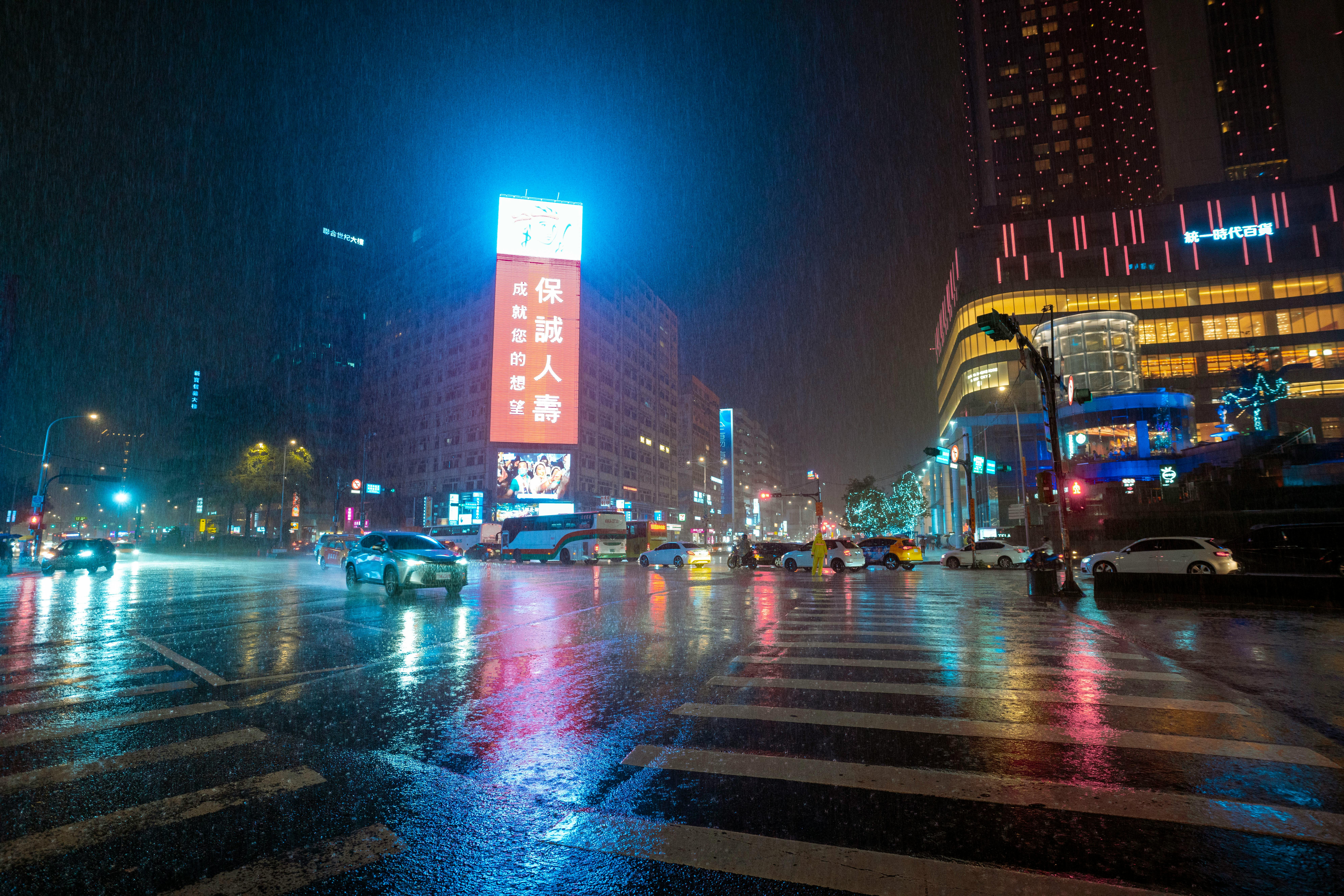 Дощова вечірня вулиця: рух авто та пішоходів