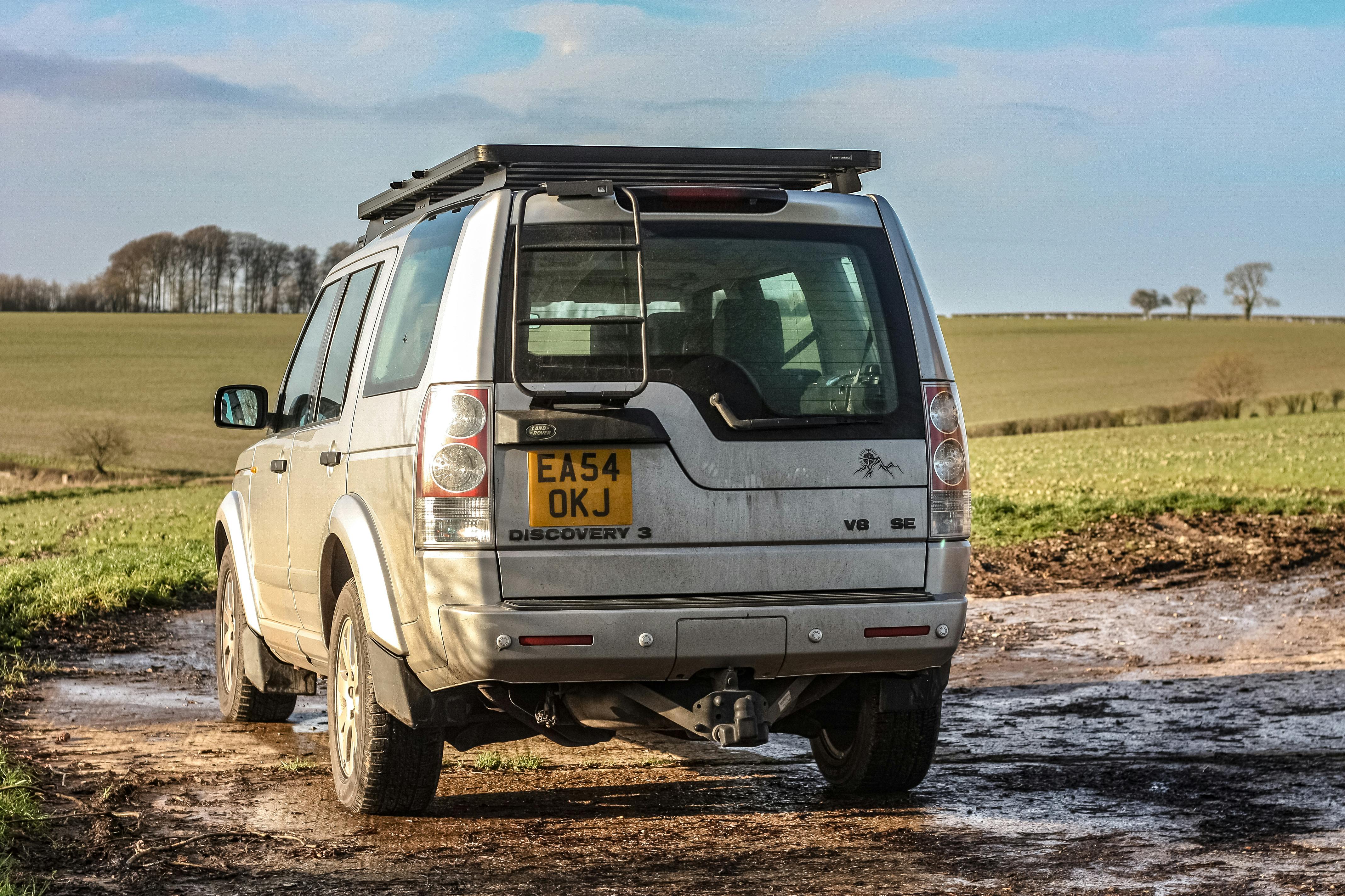 SUV argintiu pe un drum de pământ noroios după ploaie
