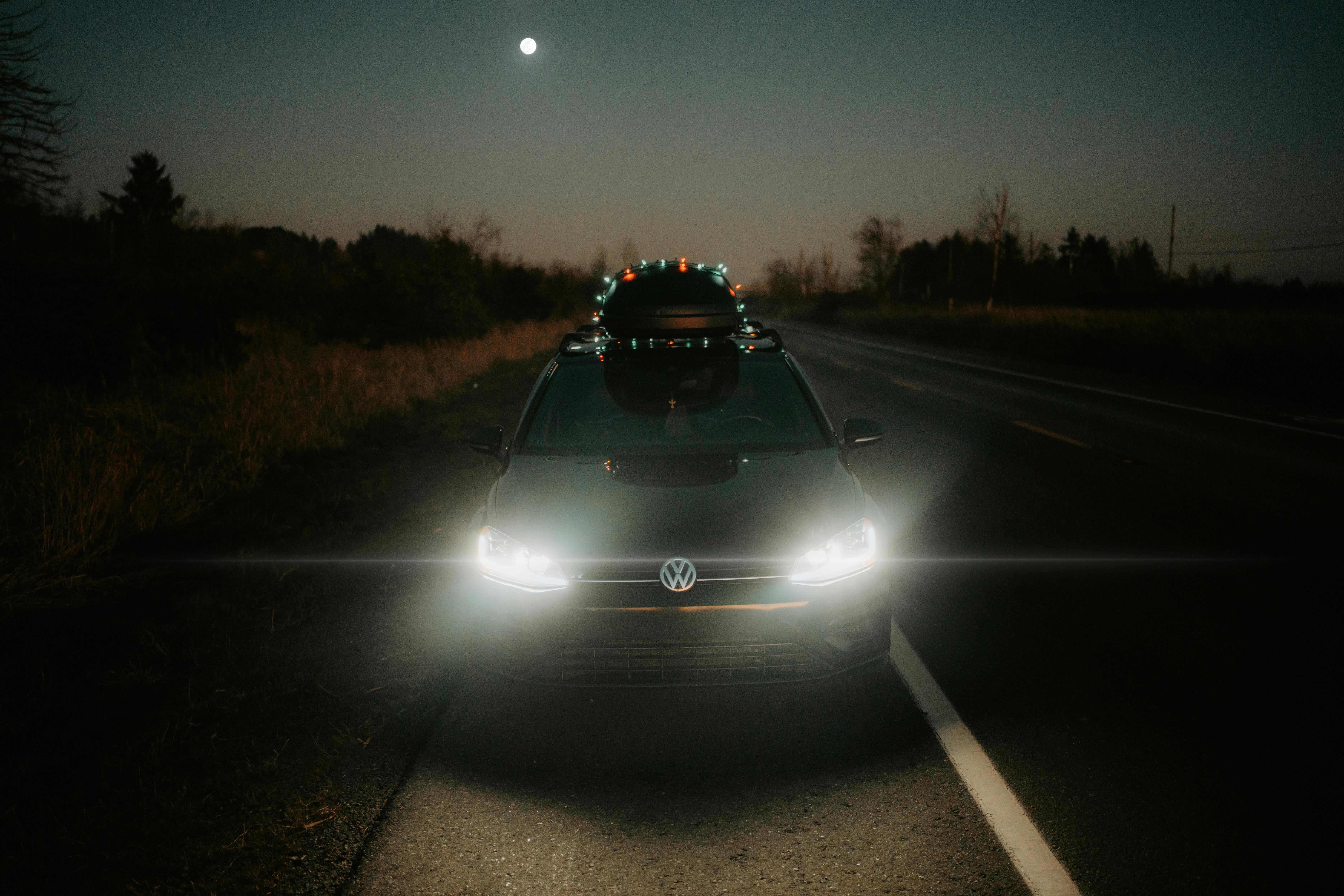 Автомобільні фари вночі освітлюють темну дорогу