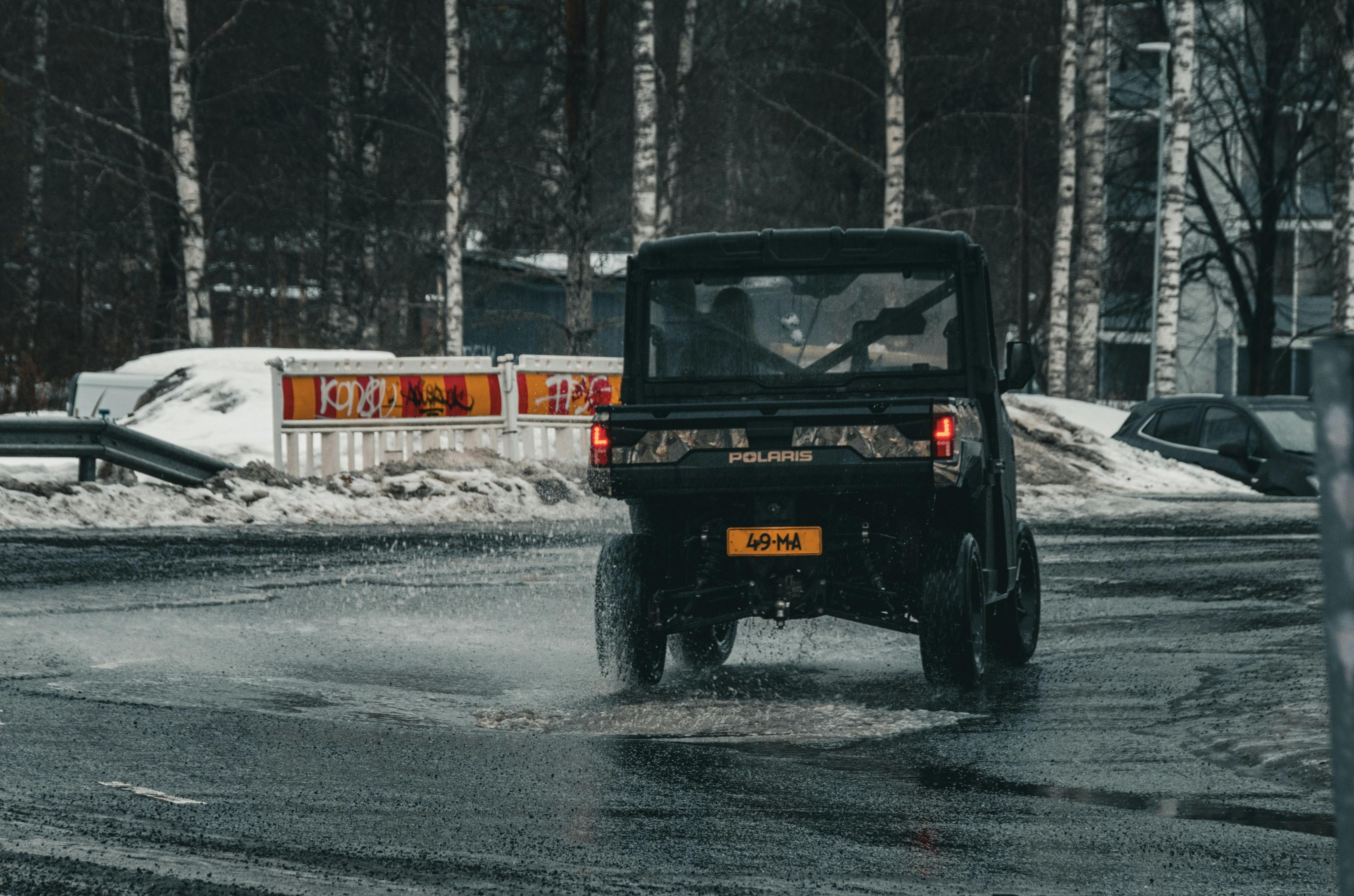 Mașină mergând pe asfaltul umed de iarnă în Finlanda