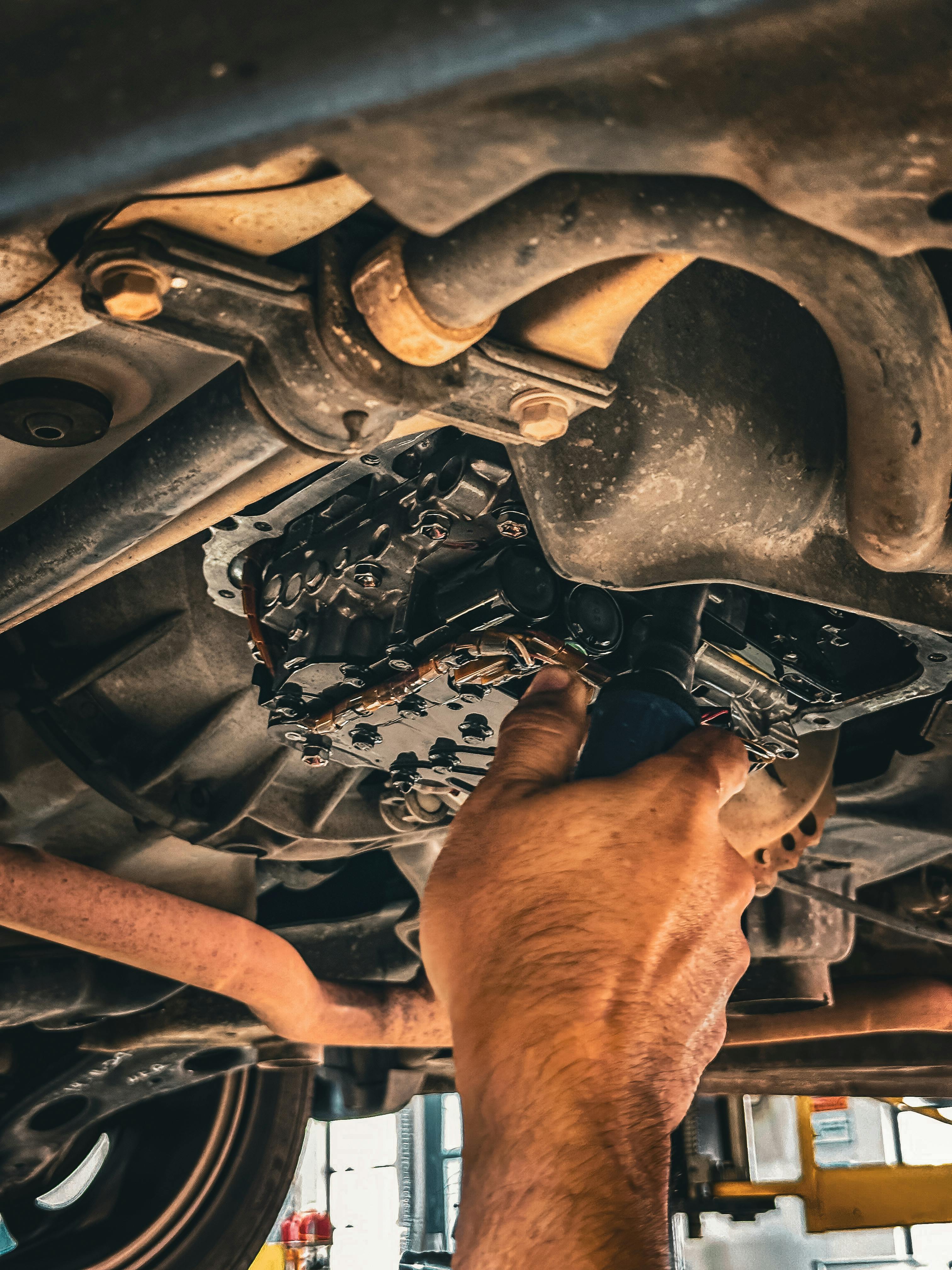 Un mecanic inspectează sistemul de evacuare – zona unde se află DPF-ul și senzorii